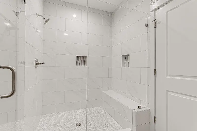 Modern white tiled walk-in shower enclosure.